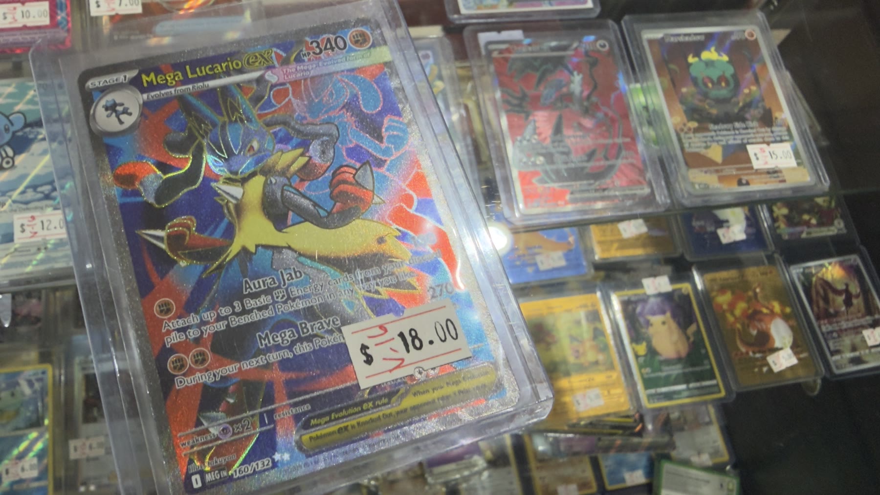 Mega Lucario EX Pokémon card priced at eighteen dollars in a display case