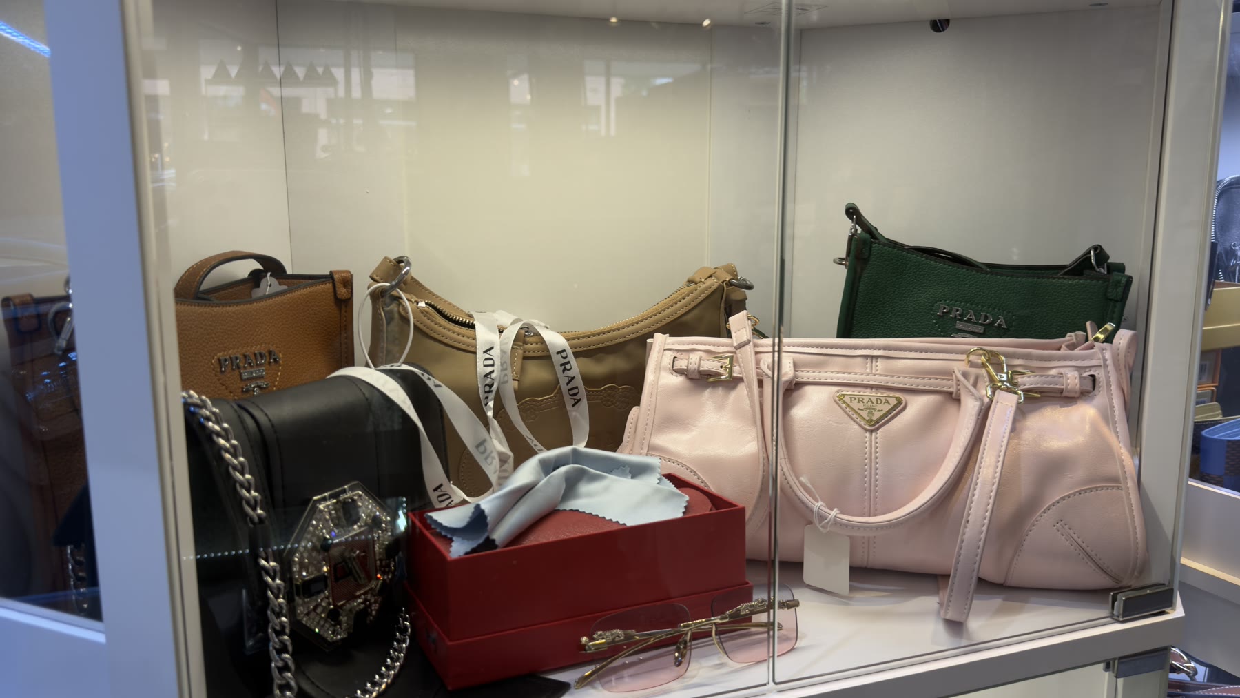 Designer Prada handbags in a glass display case
