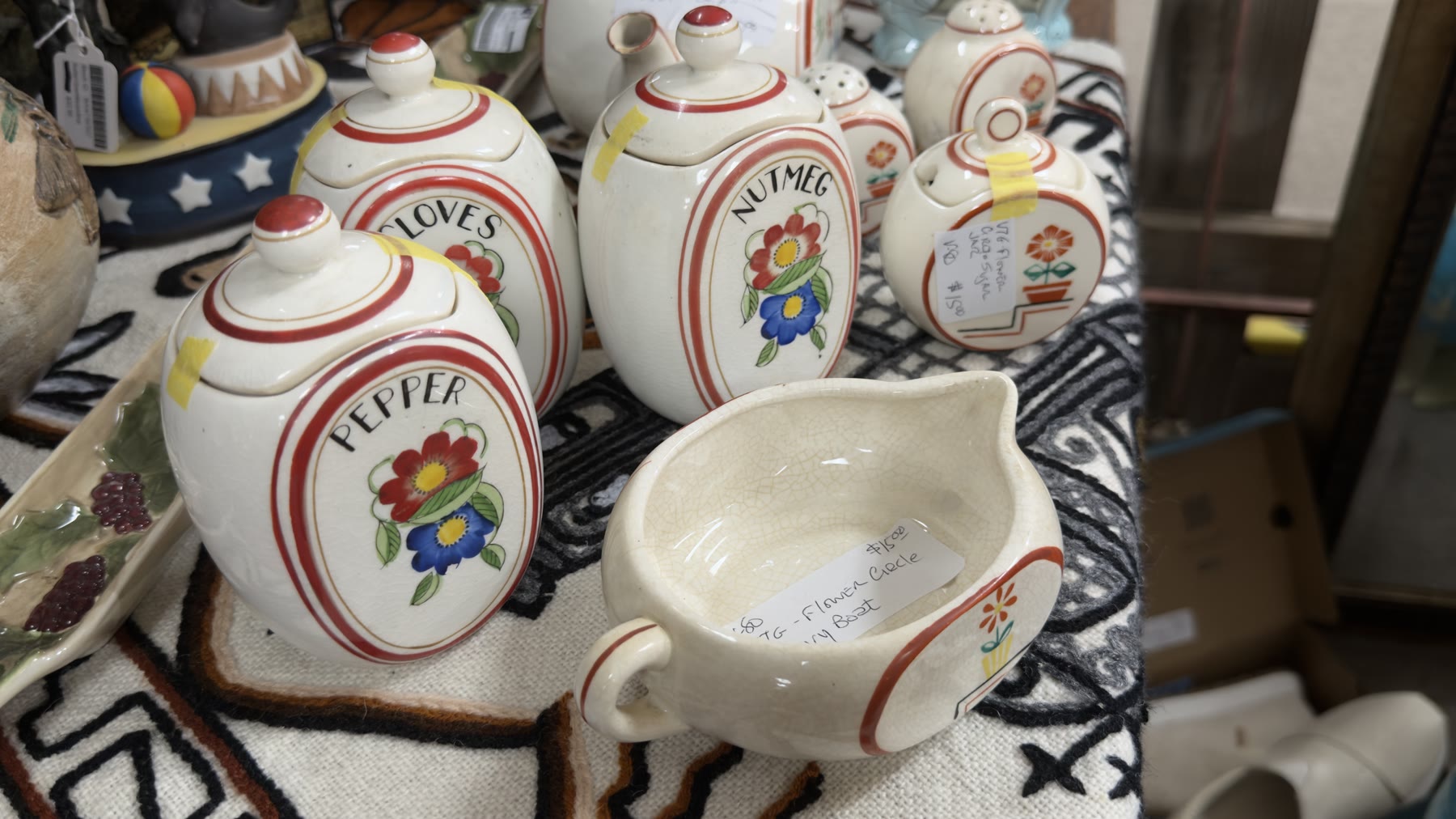 Vintage ceramic spice jars labeled Pepper Cloves Nutmeg with red flower motifs