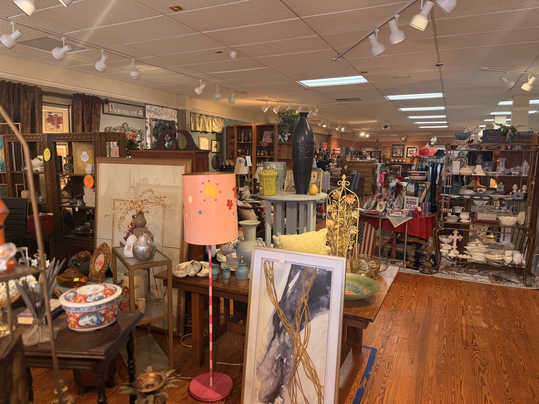 Antique vases, framed art, and a star-shaped lampshade in a curated booth
